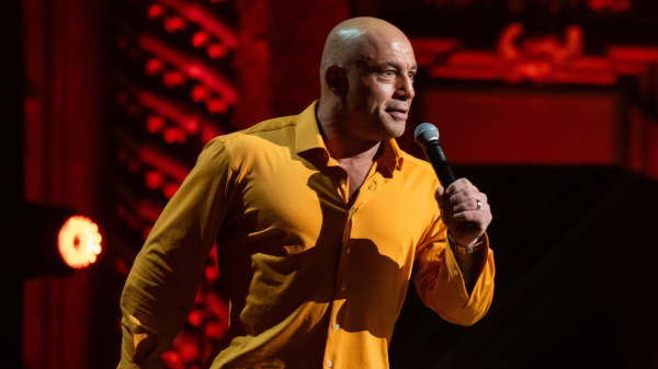 Joe Rogan hosting The Joe Rogan Experience podcast — a key factor in his net worth growth